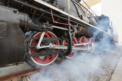 户外红黑涂装的老式蒸汽火车的驱动轮