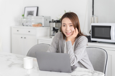 一名女性在家里使用笔记本电脑办公或休闲娱乐