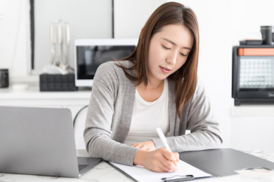 一名女性在家办公记录工作内容