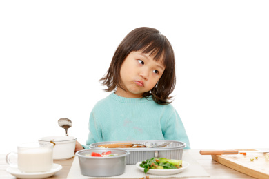 饭桌上不想吃饭不开心的小女孩