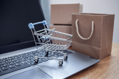 办公桌上的笔记本电脑和网购纸箱购物车背景素材 