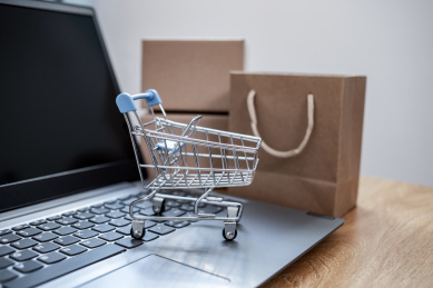 办公桌上的笔记本电脑和网购纸箱购物车背景素材 