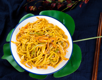 一个白色盘子碗装满炒面放着暗色背景上