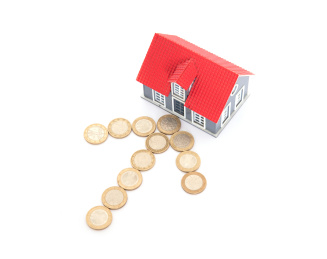 白背景上欧元硬币摆成的箭头符号指向房屋模型