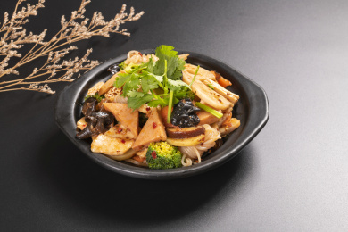 由多种食材烹调而成的川菜麻辣香锅摆放在黑色背景上