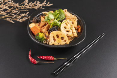 由多种食材烹调而成的川菜麻辣香锅摆放在黑色背景上