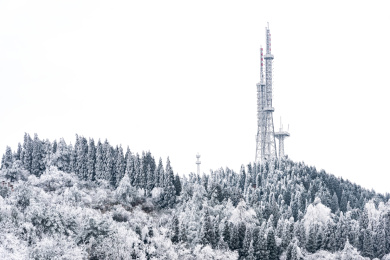 冰雪覆盖的森林与冰冻的信号发射塔