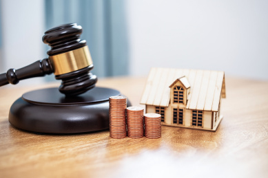 桌子上的法槌拍卖锤和小房子，房产抵押拍卖     