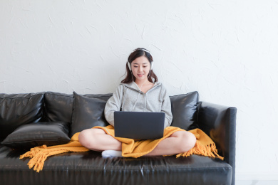 一个年轻的东方女人在家使用电脑