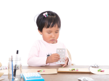 白背景前中国小女孩扮演大夫抓药