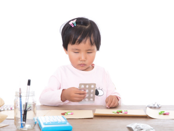 白背景前中国小女孩扮演大夫抓药