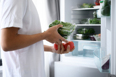年轻亚洲男人从冰箱里拿食材