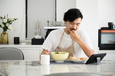 年轻亚洲男人在家吃早饭