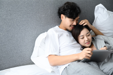 年轻亚洲情侣在家使用平板电脑