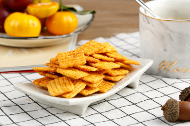 放在格子布上的一小盘零食小吃锅巴