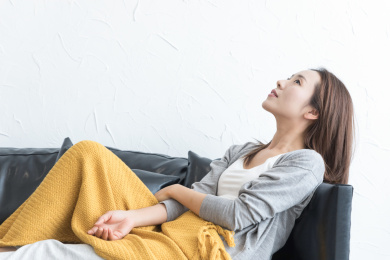 一名年轻女性躺在家里沙发上休息