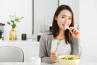 拿着面包正在吃早餐的年轻女性