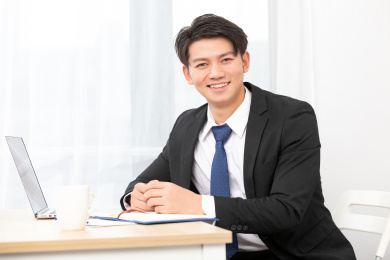  亚洲商务男士坐在桌子旁边正在使用电脑， 金融商业保险