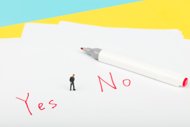 西装男性站在红色的Yes和No旁抉择