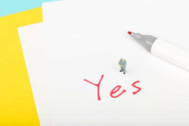 西装男性站在红色的yes旁宣布