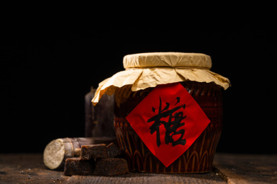 纯色背景下摆放着一个老式糖罐和多个红糖块