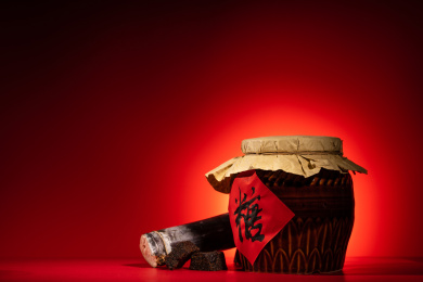 纯色背景下摆放着一个老式糖罐和多个红糖块