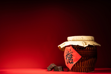 纯色背景下摆放着一个老式糖罐和多个红糖块