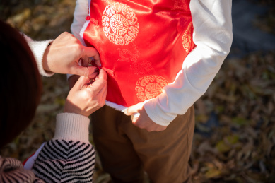 过年给男孩系扣穿新衣服