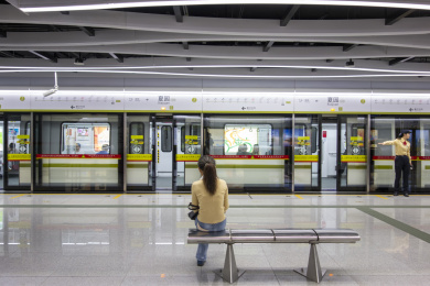 一位女士在地铁站坐在椅子上等车