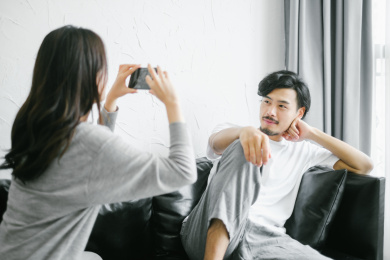 情侣坐在沙发上用手机拍照
