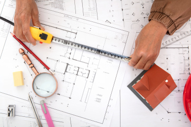 俯视拍摄建筑设计师使用卷尺测量图纸的精度