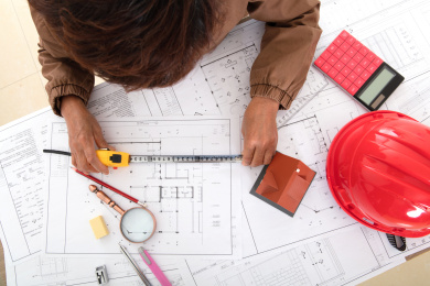 俯视拍摄建筑设计师使用卷尺测量图纸的精度