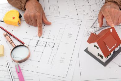 俯视拍摄设计师对比着房屋模型检查图纸