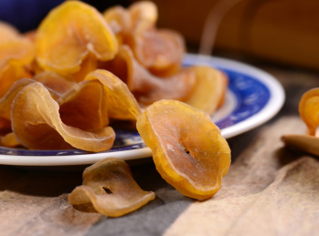 木纹背景上陶瓷餐具里摆放的萝卜干