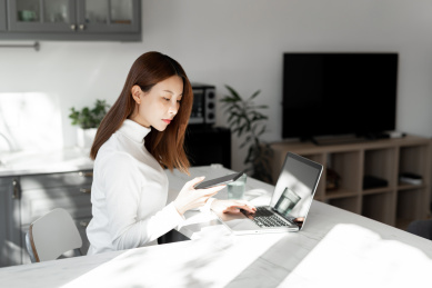 一位年轻女性在沙发上使用笔记本电脑