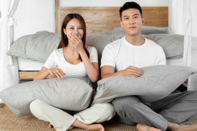 一对情侣正在床前开心的打闹