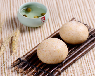 棕色竹排上摆放的杂粮面豆沙包