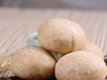 棕色竹排上摆放的杂粮面豆沙包