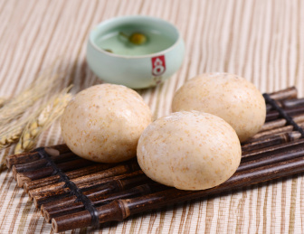 棕色竹排上摆放的杂粮面豆沙包