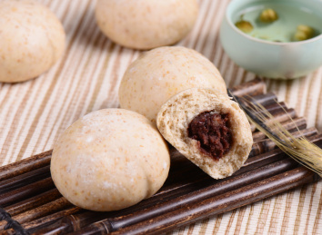 棕色竹排上摆放的杂粮面豆沙包