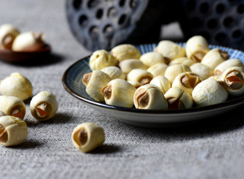 灰色背景上餐具里摆放的莲子颗粒