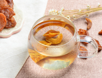 浅色背景上泡在玻璃器皿中的杏干