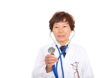 坐诊的女医生手拿听诊器诊病