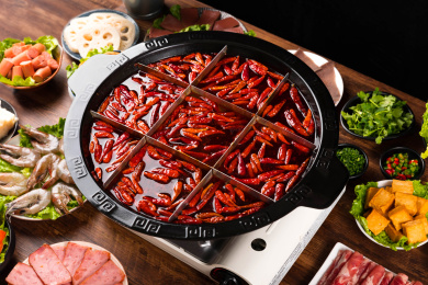 餐桌上摆满火锅食材，中间还有一盆九宫格火锅浓汤