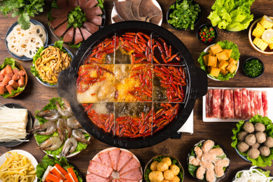 餐桌上摆满火锅食材，中间还有一盆九宫格火锅浓汤