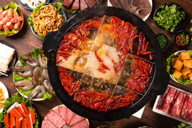 餐桌上摆满火锅食材，中间还有一盆九宫格火锅浓汤