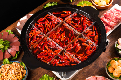餐桌上摆满火锅食材，中间还有一盆九宫格火锅浓汤