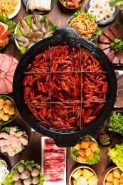 餐桌上摆放着九宫格火锅和很多的火锅食材