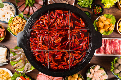 餐桌上摆放着九宫格火锅和很多的火锅食材