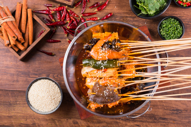 一个盆里面装有麻辣红油和火锅串串